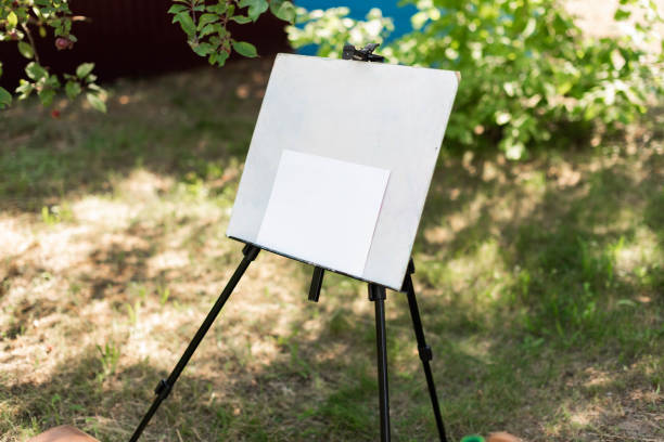 istock Blank white canvas on a modern tripod easel in the garden 2162752096