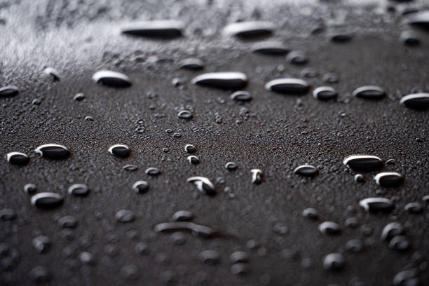 Water Beading Effect on Vehicle Water beading effect after car detailing. To prevent or reduce water stain. Spray ceramic wax water on black surface stock pictures, royalty-free photos & images