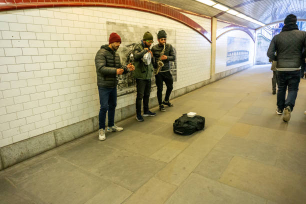 London, United Kingdom - September 3, 2011:  A street musician (busker) performing at underground tube station in London with a playing piano