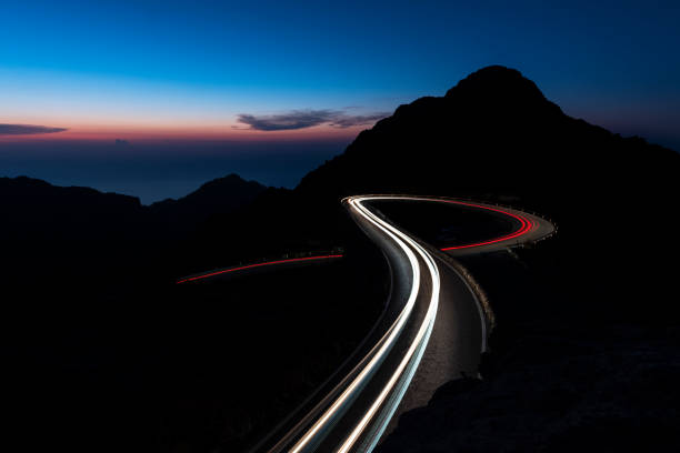 istock Car trails lights on winding road, Spain 2162760231