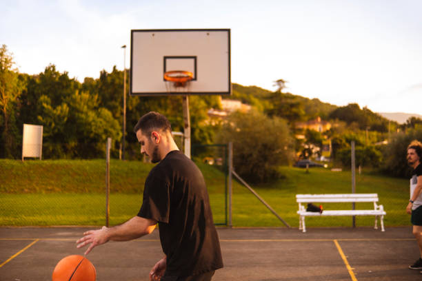 istock Young man playing basketball at sunset 2162760749