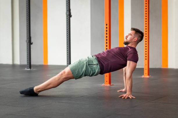 Young strong man performing calisthenics reverse plank exercise