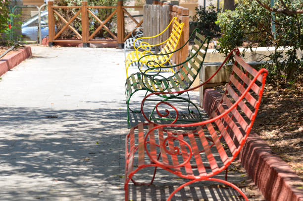 Benches at the park in summer showcase a vibrant array of colors, creating a cheerful and inviting atmosphere.