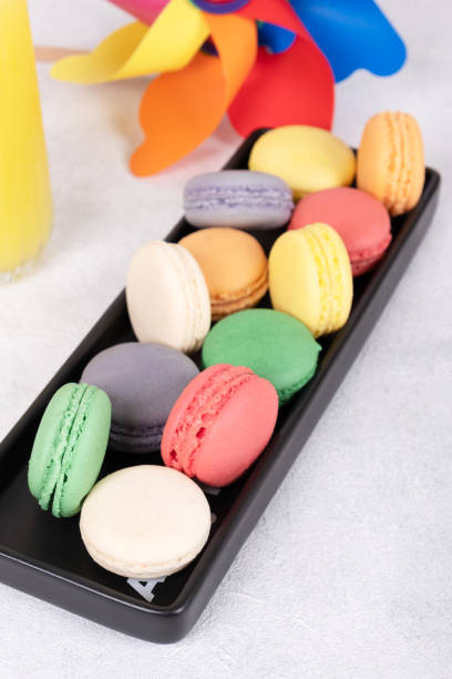 A Colorful Array of Macarons on a Black Plate: A Delightful and Vibrant Treat