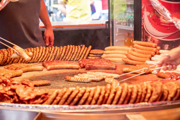 Sizzling grilled sausages on metal tray, ready to serve, backyard barbecue concept