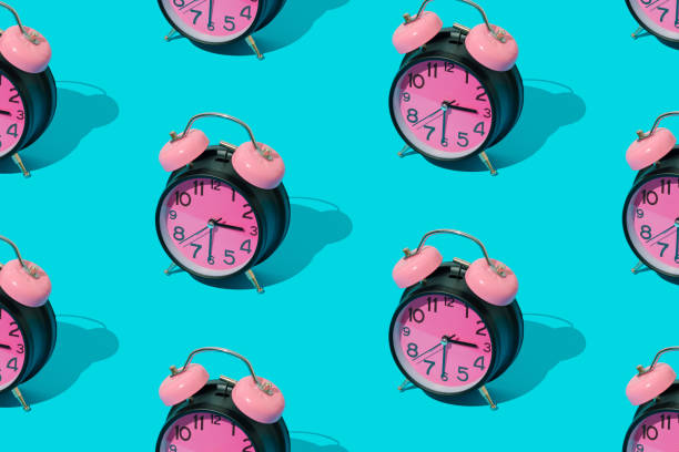 istock Trendy sunlight pattern made with pink and black retro alarm clock on bright blue background. Minimal time concept. 2162774272