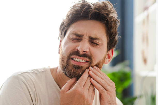 istock Young man touching cheek with hands with painful expression because of toothache 2162776477