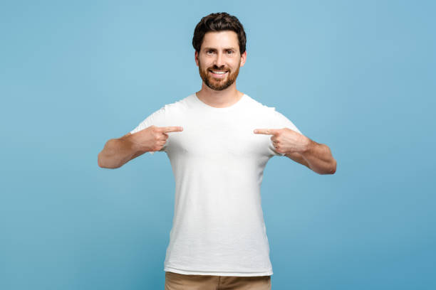 istock Smiling handsome young bearded man wearing t shirt pointing himself isolated 2162776523