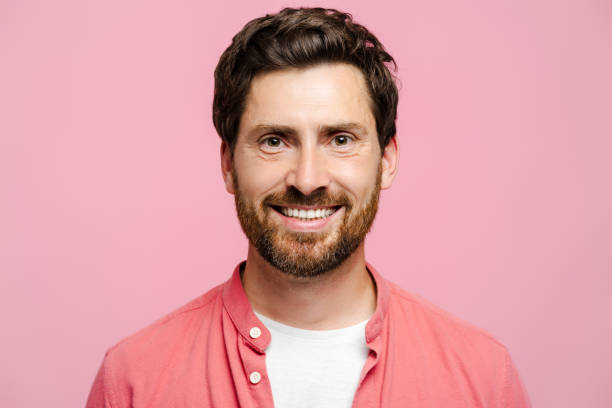 istock Smiling young man with beard looking at camera, isolated on pink background 2162776549