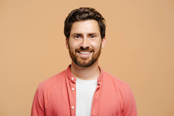 istock Happy young man with beard posing at camera, isolated on beige background 2162776562