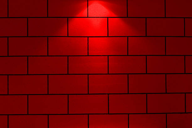 red neon spotlight with copy space. Lighting effect red color glow on brick wall background.