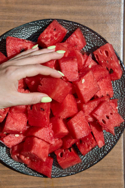 istock Female with manicured nails touching watermelon slices on plate 2162781713