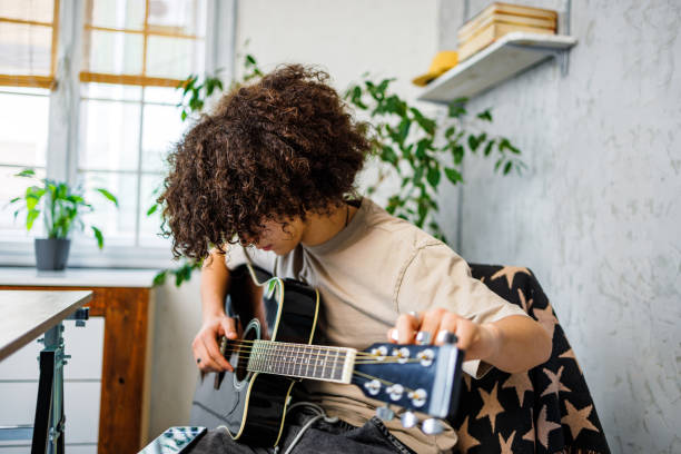 istock Young musician tuning guitar 2162782929