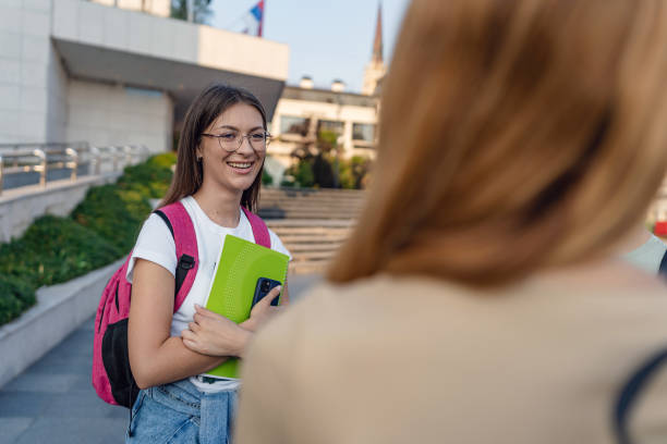 istock Smiling student chatting with friends on university campus 2162783600