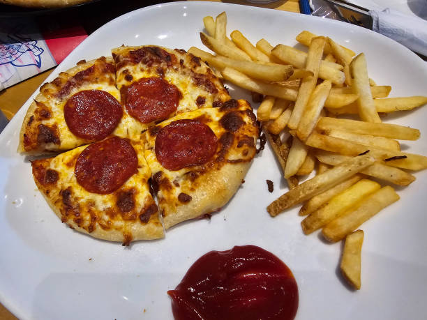 A small pizza and fries on a plate.