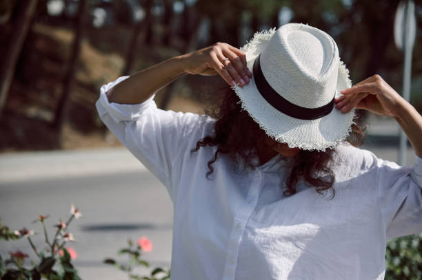 istock Woman adjusting a straw hat outdoors on a sunny day 2162792969