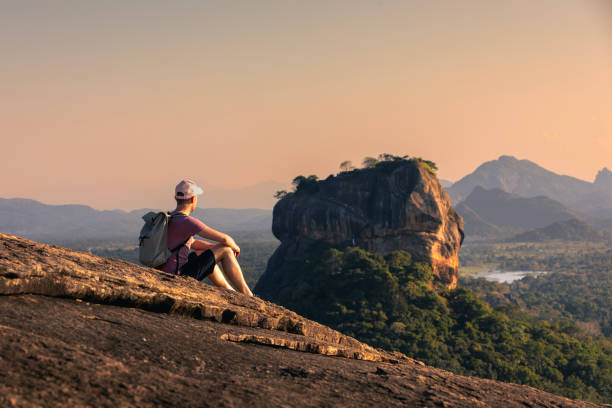 istock Man with backpack sitting on rock and looking at landscape. 2162796710