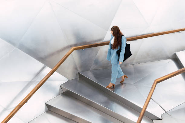 closeup young girl seen from behind with hat climbing stairs in the city