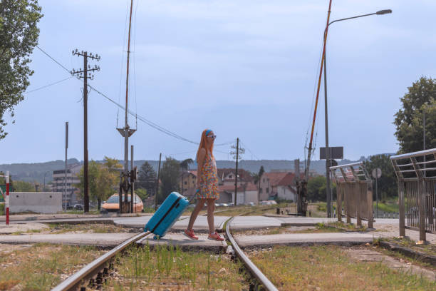 Female tourist pulling her luggage in suitcase and looking around European city