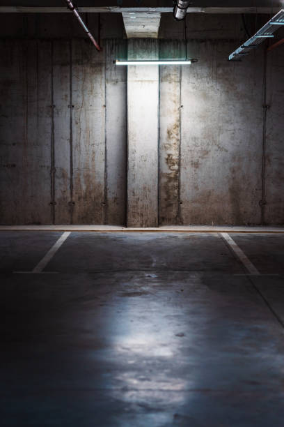 istock Empty underground garage. Parking lot with overhead dim light 2162810682