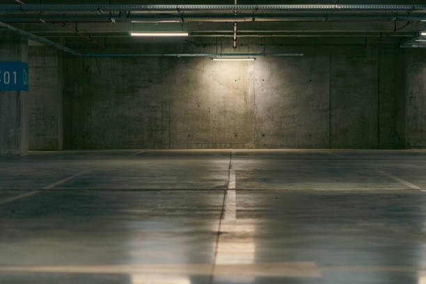 istock Empty underground garage. Parking lot with overhead dim light 2162810865