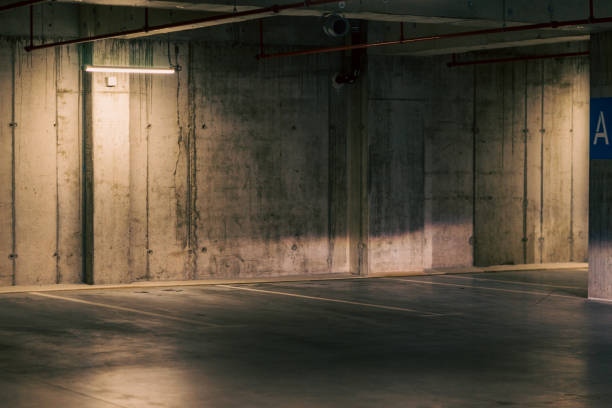 istock Empty underground garage. Parking lot with overhead dim light 2162811075