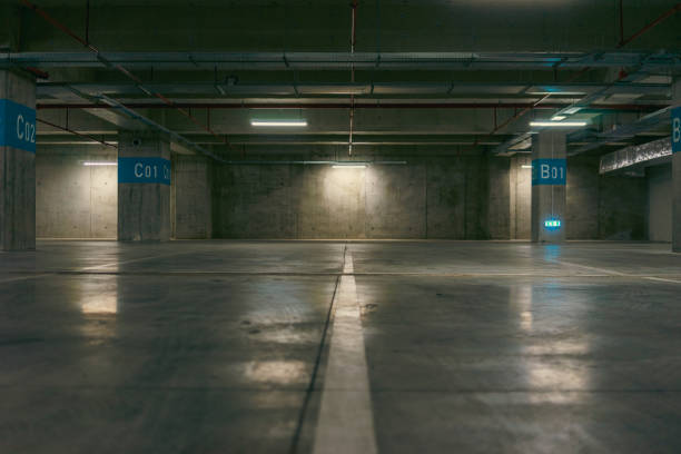 istock Empty underground garage. Parking lot with overhead dim light 2162811513