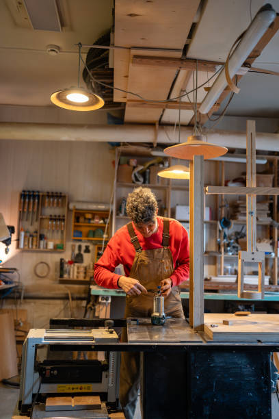 istock Carpenter prepares equipment for work. Man with wrench busy organizing workspace. 2162817957