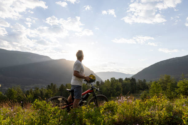 istock Mature man mountain biker pauses in meadow 2162823597
