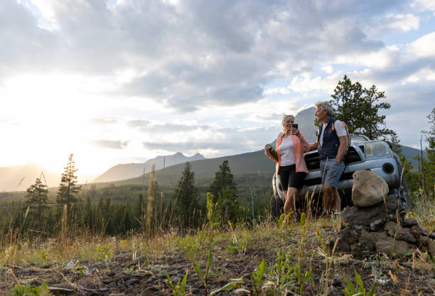 Senior hiking couple pause by vehicle
