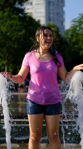 istock A girl playing outdoors in fountain 2162830102