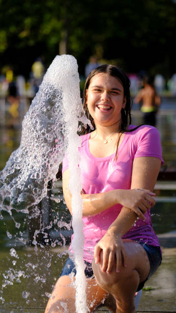 istock A girl playing outdoors in fountain 2162830175