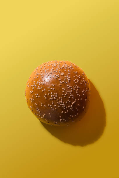 istock A hamburger bun on a yellow background. Copy space. 2162830202