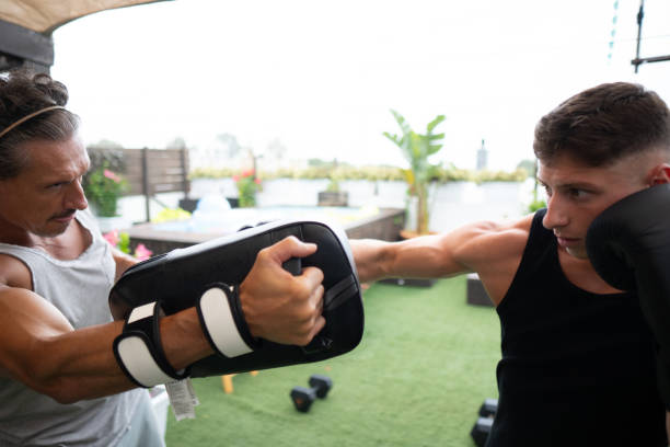 Young athlete practicing boxing with his personal trainer on a rooftop