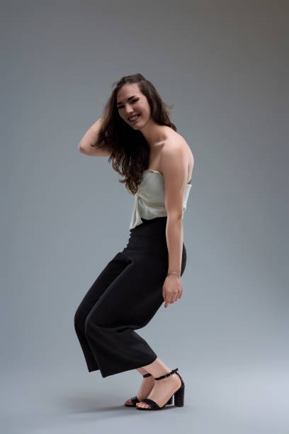 istock Young woman posing and touching her hair in studio 2162833031