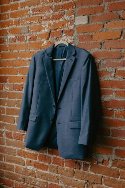 istock Blue suit jacket hanging on a brick wall, showcasing a stylish and formal attire 2162833417