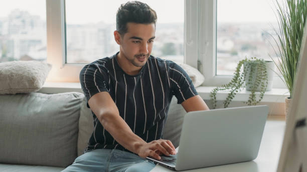 istock Distance work freelancer man laptop desk home 2162834575