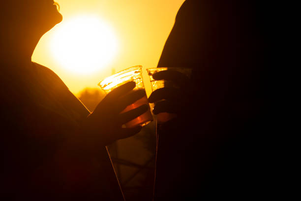 istock Close Up of Couple Holding Drinks at Sunset 2162852488