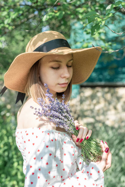 Young beautiful woman picking lavender flowers