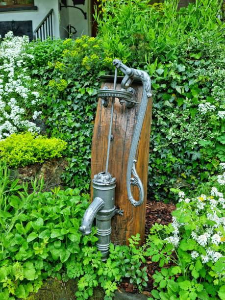 Traditional hand water pump Vianden, Luxembourg - May 03, 2024: Wood attached of well preserved traditional hand water pump old fashioned well hand pump stock pictures, royalty-free photos & images