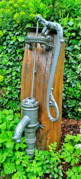 Traditional hand water pump Vianden, Luxembourg - May 03, 2024: Wood attached of well preserved traditional hand water pump old fashioned well hand pump stock pictures, royalty-free photos & images