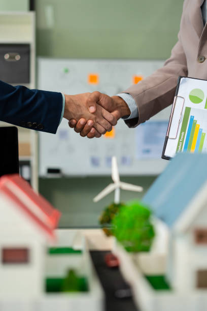 Businessmen shake hands after agreeing to start a new project successfully, renewable and sustainable development, and solar panel concept.