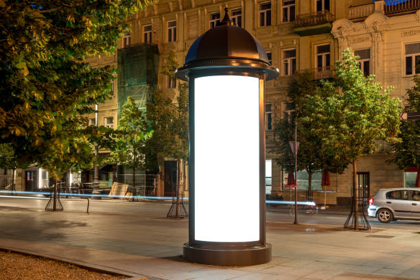 Mockup Of Round Lightbox Display In A City Square At Night. Retro Style Billboard Stand