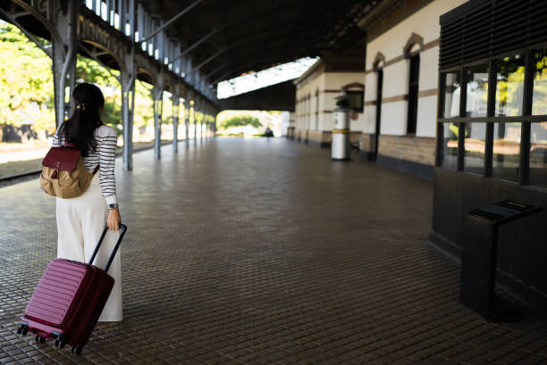 Young asian woman traveler with suitcase in the railway