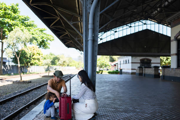 asian family on train station opening suitcase
