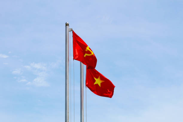 istock Vietnamese and Communist Flags Waving in the Sky 2162864937