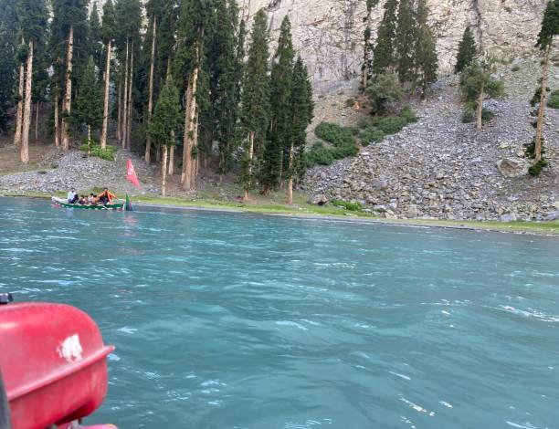 tourists enjoying boating in fresh water Mahdund Lake in Kalam Pakistan