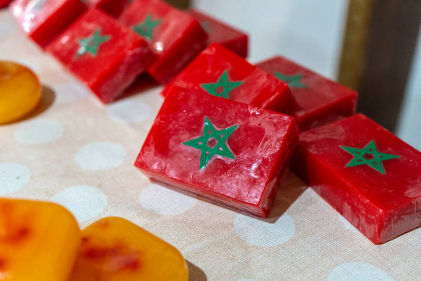 Assorted handmade soap bars displayed on a table. Moroccan soap varied shapes, tourist souvenir, gifts. Unique scents. Decorative, artisan soap. Craft fair.