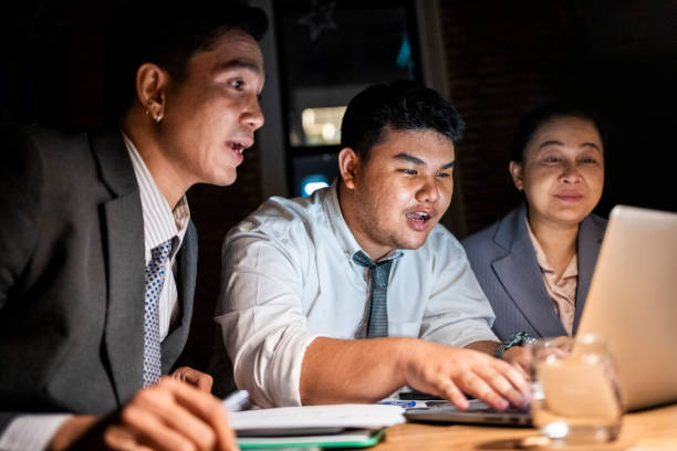 istock Late night office meeting with team using laptop 2162867041