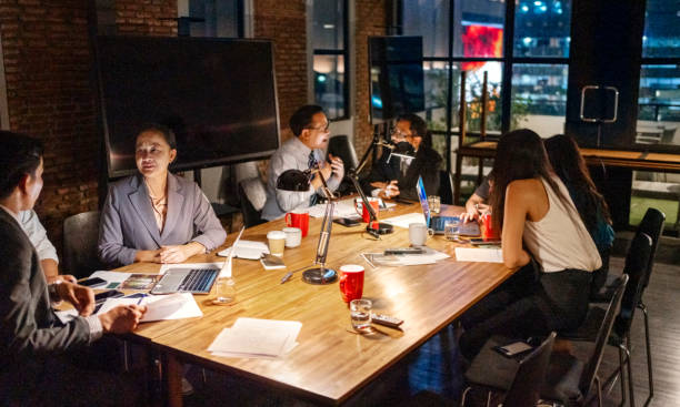 istock Executives collaborating in office boardroom during late night meeting 2162867043